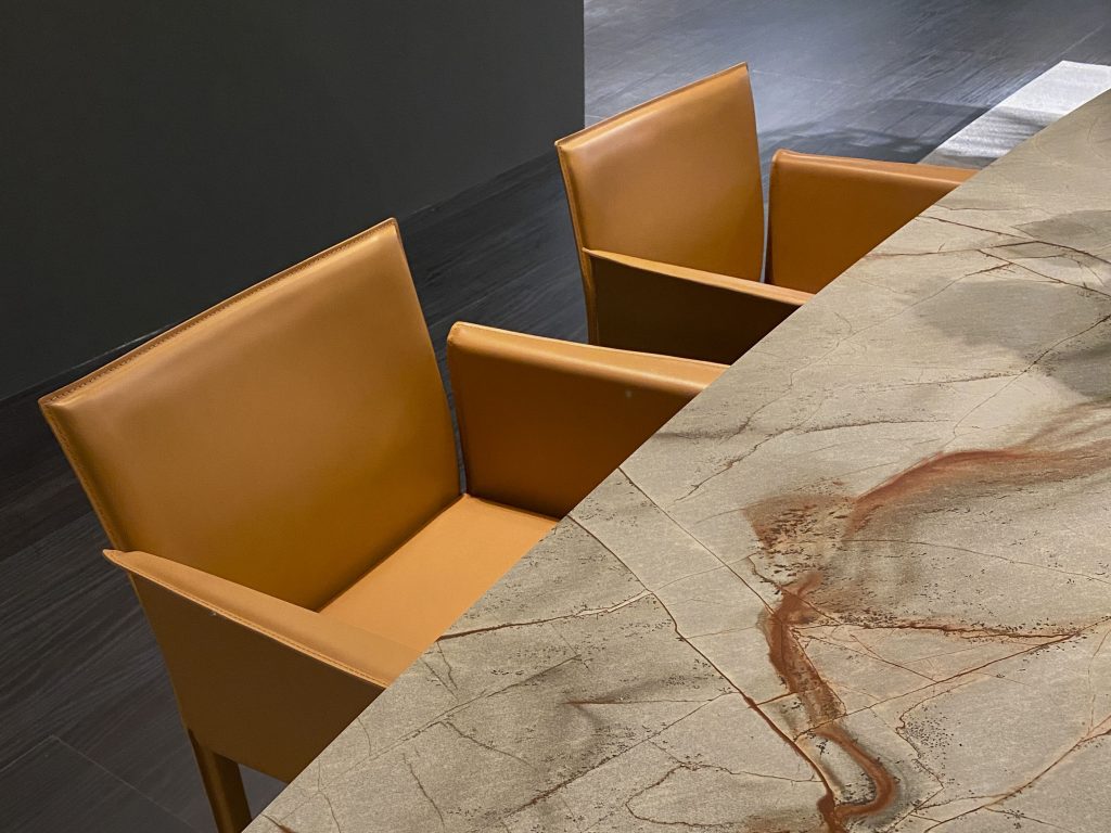 Stone table top and pumpkin orange leather chairs